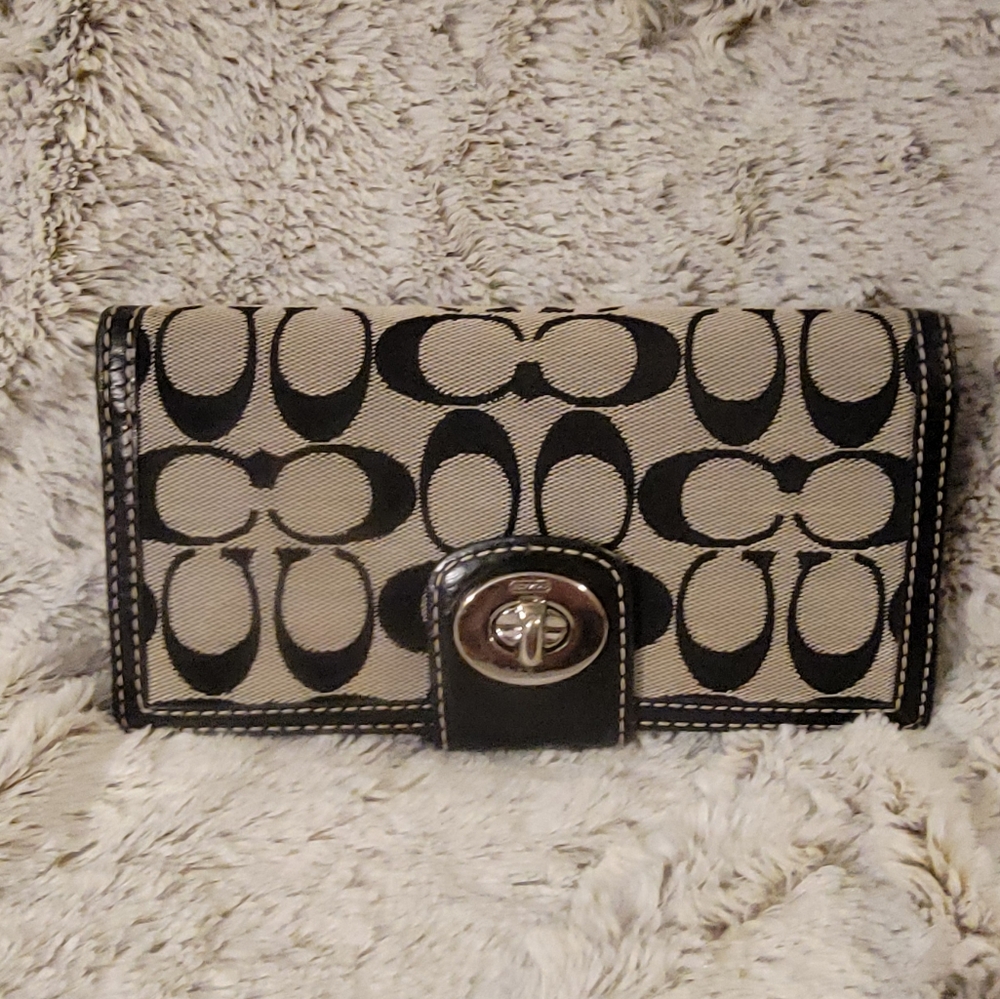 Coach black and white monogrammed wallet with a checkbook cover.